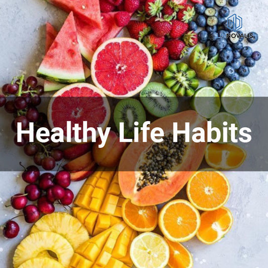 Flat lay of fresh fruits, water glass, and a journal on a wooden table, bright natural light