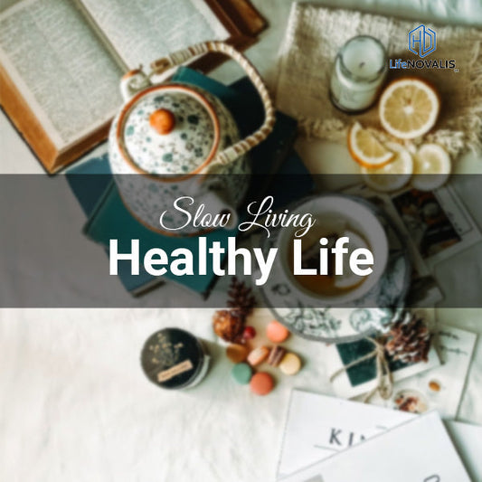 Flat lay of a journal, herbal tea, and fresh flowers on a wooden table with soft daylight